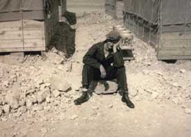 Arnold Ladnier sitting on ground resting head on hand